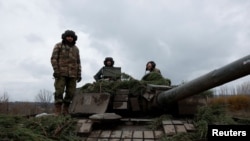 Soldații ucraineni se pregătesc să tragă dintr-un tanc T80, capturat de la ruși. Fotografie generică. 