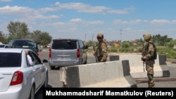 Силы безопасности охраняют дорогу во время организованного правительством пресс-тура. Каракалпакстан, Нукус, 6 июля 2022 года.