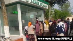 Люди стоят в очереди за наличными деньгами возле филиала «Агробанка» в Чартакском районе Наманганской области, 7 апреля 2020 года. 