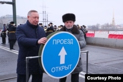Guvernatorul Sankt Petersburg Alexandr Beglov (stânga) și magnatul Igor Bukato inaugurează traficul pe un pod renovat.