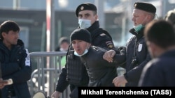 Российская полиция ведет иностранного гражданина в центра временного содержания. Иллюстративное фото. 