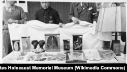 Американски военни патолози показват намереното в една от лабораториите в лагера Бухенвалд – простреляно човешко сърце във формалин, парчета татутирана човешка кожа, абажур за лампа, направен от човешка кожа, 16 април 1945 г.