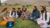 Un turist german discută cu localnicii și cu oficiali talibani în provincia Panjshir din nord.