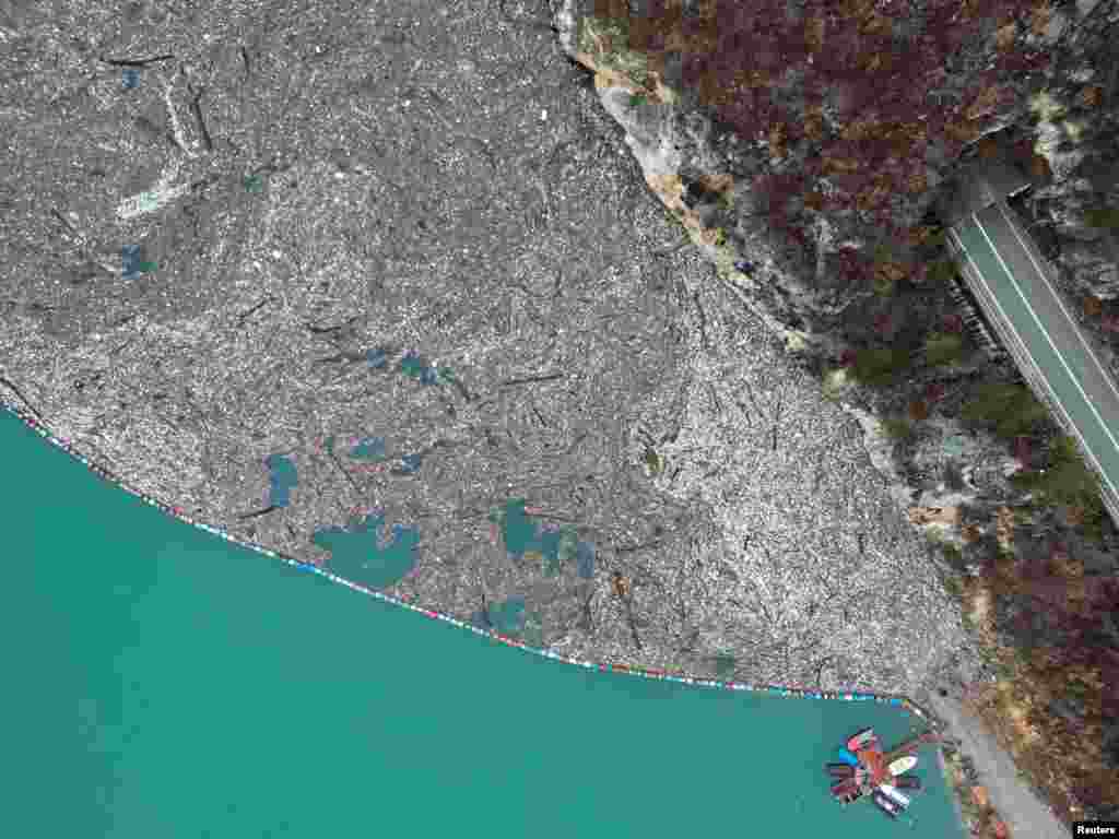 Vedere aeriană a râului poluat, la 5 ianuarie. Pentru a proteja barajul de deșeurile purtate de râu, în urmă cu 20 de ani hidrocentrala din Visegrad a construit o barieră din butoaie vechi de oțel, ce izolează zona.&nbsp;(Reuters)