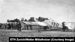 Местни жители помагат на Мителхолцер да издърпа самолета си на позиция за излитане