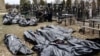 Поліцейські поруч із тілами загиблих під час російської окупації Бучі на місцевому кладовищі, квітень 2022 року