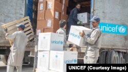 په هرات کې د ملګرو ملتونو کارکوونکي له لاريوو مرسته شوي سامانانونه کښته کوي - انځور له ارشیفه