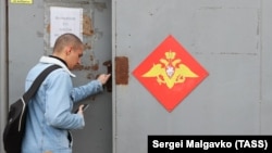 Орусиядагы аскер комиссариатына кирип бараткан улан. 