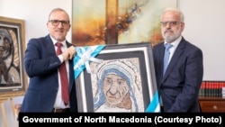Премиерот Талат Џафери во посета на Универзитетот Мајка Тереза во Скопје, фотографиран со ректорот Изет Зекири и слика од Мајка Тереза.