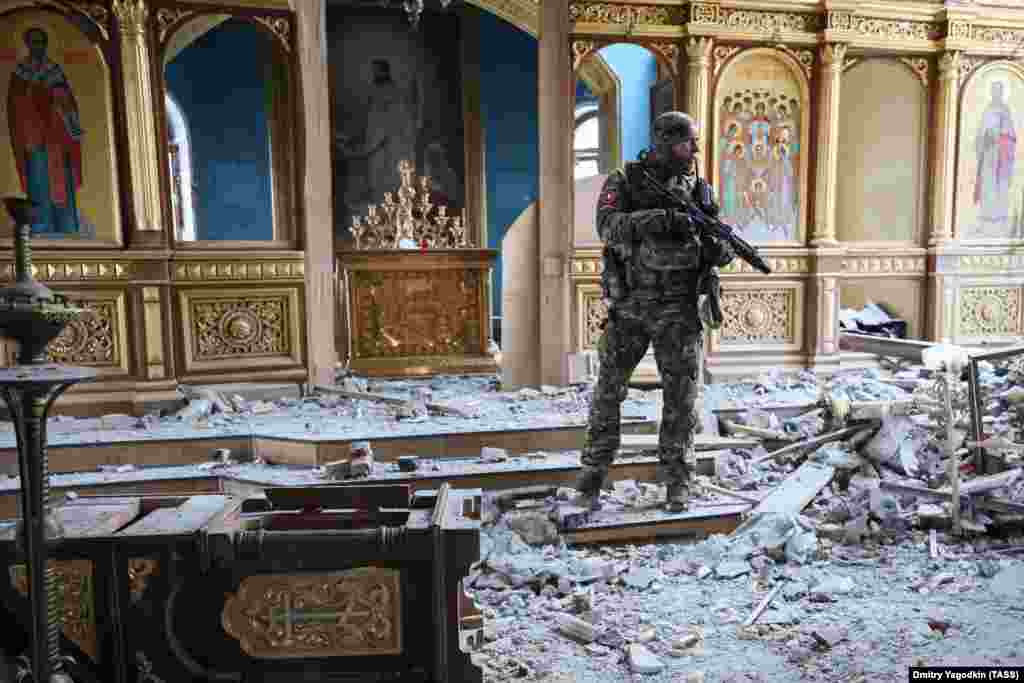 Войник, носещ значката на международната бригада "Пятнашка" - бойна единица, основана от етнически абхази, се разхожда в църквата "Свети Михаил" в Авдиивка.