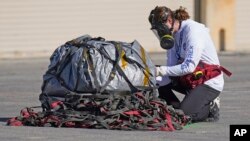 Член на екипа за възстановяване преглежда капсулата с първите проби от астероиди на НАСА, преди да я пренесе във временна лаборатория в полигона Дъгуей в Юта в неделя, 24 септември 2023 г. 