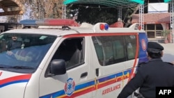 په پېښور کې یو امبولانس په برید کې ژوبل سړی روغتون ته لېږدوي، ورسره نېږدې یو پولیس پهره کوي - انځور له ارشیفه.