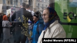 Femeie într-o stație de autobuz în apropiere de Primăria Chișinăului, urmărind Marșul Feminist, pe 8 martie 2024 