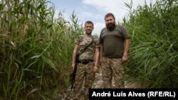 Украинските войници Ростислав (вляво) и Александър патрулират брега на реката в село Приморске