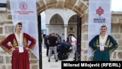 Djevojke u narodnoj nošnji dočekuju posjetioce na ulazu u obnovljenu džamiju Arnaudiju u Banjaluci, tokom otvaranja 7. maja, na 31-godišnjicu njenog rušenja 1993.