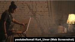 Feride Kurtmamedova resim yapa. Youtube/Ismail Kurt_Umer videosınıñ bir levhası