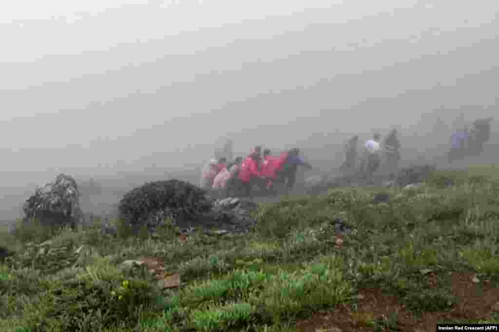 Captură din filmarea făcută de Semiluna Roșie Iraniană - pe 20 mai, echipele de salvare încearcă să recupereze trupurile celor decedați în accidentul de elicopter în care și-a pierdut viața președintele Iranului, Ebrahim Raisi. Aparatul de zbor s-a prăbușit într-o zonă muntoasă din nord-vestului Iranului. Raisi, în vârstă de 63 de ani, și ceilalți pasageri, printre care și ministrul de Externe iranian, Hossein Amir-Abdollahian, au murit la locul accidentului.