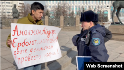 Республика алаңына пикетке шыққан Темірлан Еңсебекке (сол жақта) акция заңсыз екенін айтып тұрған полиция қызметкері. Алматы, 9 ақпан, 2024 жыл.