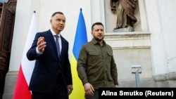 Polish President Andrzej Duda (left) and Ukrainian President Volodymyr Zelenskiy talk after a church service in Lutsk on July 9.