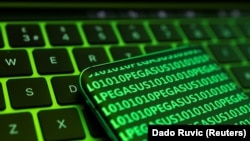 The word Pegasus and binary code are displayed on a smartphone which is placed on a keyboard in this illustration taken May 4, 2022. 