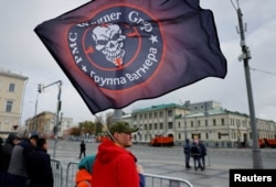 Un spectator cu un steag al grupării Wagner la parada victoriei de la 9 mai, 2024, la Moscova.