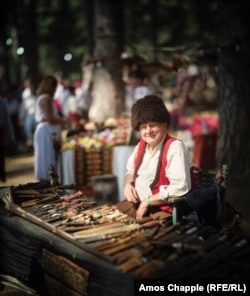 Маж покажува домашно изработени ножеви.