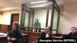 ლაზარე გრიგორიადისი და მისი უფლებადამცველები უყურებენ პროკურატურის მიერ წარმოდგენილ ვიდეომტკიცებულებებს. 25 ოქტომბერი, 2023 წელი 