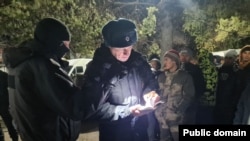 Полицейский проверяет документы у мигрантов. Октябрь 2023 