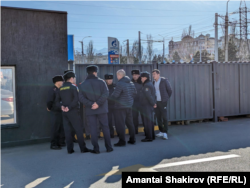 Акциянын уюштуруучуларына байкоо салып турган милиция кызматкерлери.