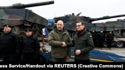 Керівники урядів України і Польщі, Денис Шмигаль та Матеуш Моравецький (праворуч), біля перших танків Leopard 2, доставлених із Польщі до України, 24 лютого 2023 року