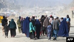 د افغان کډوالو کورنۍ پر تورخم افغانستان ته د اوښتو لپاره پلي روان دي - د نومبر دویمې انځور.