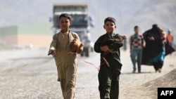 په تورخم کې دوه کډوال ماشومان له خپلو چرګانو سره افغانستان ته داخلېږي - د نومبر دویمې انځور.