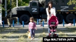 Жители оккупированной Россией части Херсонской области на фоне российской военной техники