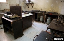 O pisică este fotografiată în bucătăria unui cămin de muncitori străini din zona industrială Sanaya din Doha, 3 mai 2015. Muncitorii și grupurile de apărare a drepturilor omului au acuzat în repetate rânduri condițiile de trai.