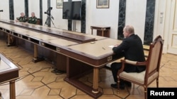 Ресей президенті Владимир Путин (оң жақта) қорғаныс министрі Сергей Шойгу мен бас штаб бастығы Валерий Герасимовке Ресей ядролық қаруын арнайы тәртіпке көшіруді тапсырып отыр. Мәскеу, 27 ақпан 2022 жыл.