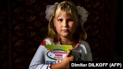  9-річна Антоніна із підручником української мови після онлайн-уроку в перший навчальний день у себе вдома в селі Покровське на Миколаївщині неподалік від фронту, 1 вересня 2022 року