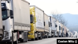 Чек арада кезек күткөн оор автоунаалар. 