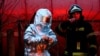 Украинанын куткаруу жана өрт өчүрүү кызматынын өкүлдөрү Львовдогу орус күчтөрү сокку урган кара май кампасындагы өрттү өчүрүүгө аракет кылып жатат. 26-март,  2022-жыл. 