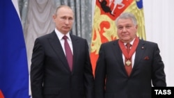 Președintele rus Vladimir Putin (stânga) prezentând un premiu colaboratorului său apropiat, directorul Institutului Kurchatov, Mihail Kovalchuk, la Kremlin, în septembrie 2016.