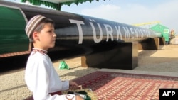 Туркменский мальчик в национальной одежде на церемонии открытия газопровода в Китай. Шаттык, 31 мая 2010 года.