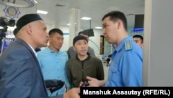 Қосай Маханбаев (сол жақта) Қаңтар оқиғасы кезінде зардап шеккен басқа да азаматтармен бірге прокуратура қызметкерімен сөйлесіп тұр. Алматы, 6 мамыр, 2022 жыл