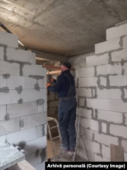 Cei doi angajați ucraineni din firma deschisă de Jenya execută lucrări de amenajări, finisaje și izolații interioare.