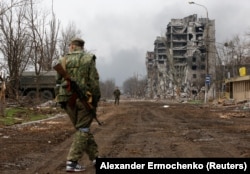 Російські військові проходять повз завод «Азовсталь» у Маріуполі, 12 квітня 2022 року