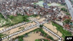 له لاهور ښار سره نېږدې سېلابي اوبه د بې کوره شویو لپاره جوړ کیمپ ته داخلې شوې دي - د اګست ۳۱مې انځور.