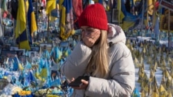 A woman cries at the memorial to the fallen Ukrainian soldiers on Independence Square in Kyiv on February 24.