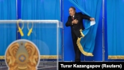 Gazagystanyň öňki prezidenti Nursultan Nazarbaýew irki prezident saýlawlary güni saýlaw uçastogynda ses beriş otagyndan çykýar. Astana, 2022-nji ýylyň 20-nji noýabry