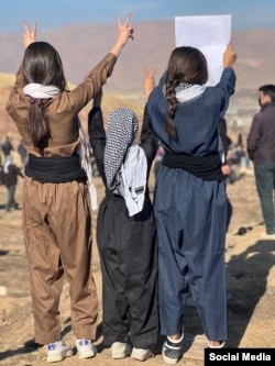 Noiembrie 2022 - trei fete iraniene demonstrează în semn de solidaridate cu protestatarii din orașul Mahabad, după moartea Mahsei Amini.