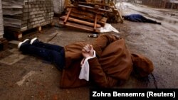 Cadavrul unui civil cu mâinile legate la spate a fost fotografiat în Bucea, pe 3 aprilie 2022, după retragerea forțelor rusești. Localnicii spun că persoana respectivă a fost împușcată de soldații ruși.
