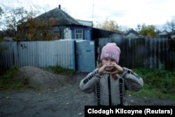 Украинанын кыштагында фотографга мээрим белгисин көрсөтүп турган кыз