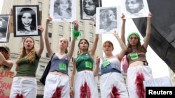 Жени в Ню Йорк протестират срещу забраната на абортите. Те носят снимки на жени, починали заради забраните за аборт в различни държави по света